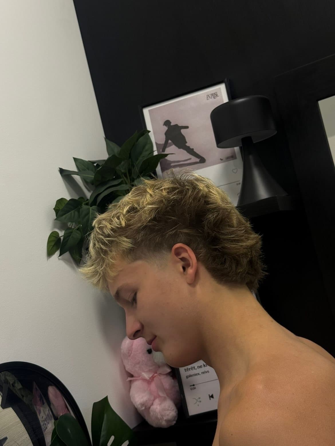 Side profile of a young man with a blonde, textured mullet haircut and faded sides.